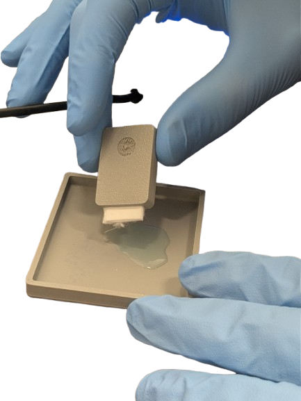 Gloved hands loading a single-use consumable