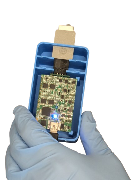The handheld reader held in a gloved hand